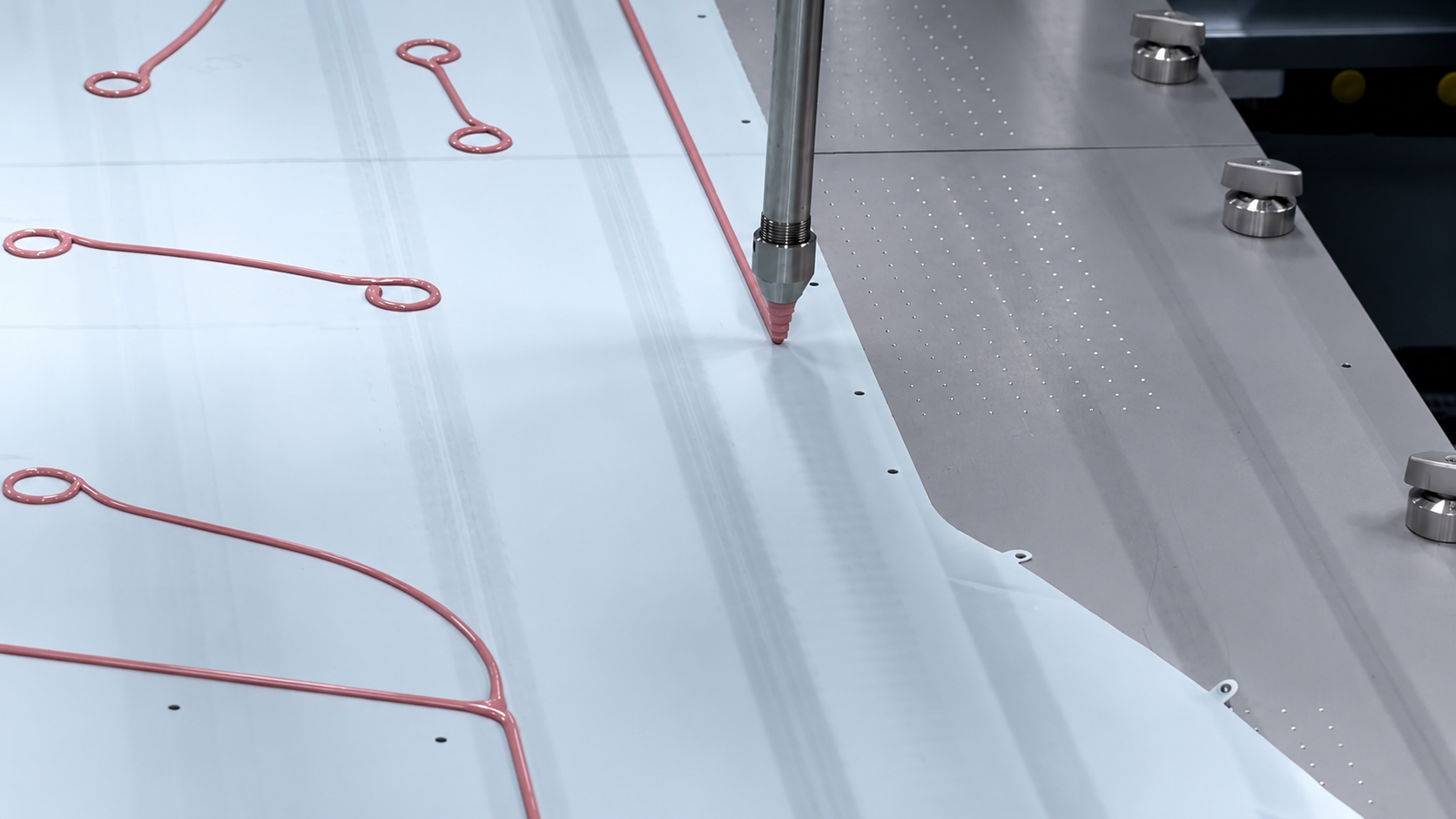 Controlled adhesive application along defined airbag paths